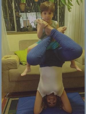 Lilian praticando yoga com o filho, simbolizando equilíbrio e bem-estar